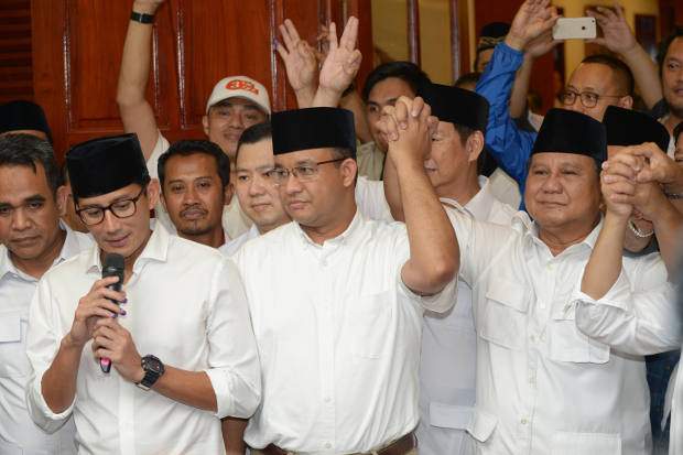 Jakarta governor-elect Anis Baswedan (center), his deputy governor-elect Sandiaga Uno (left), and Prabowo Subianto (right), celebrate during a press conference in Jakarta on April 19, 2017. (AFP)