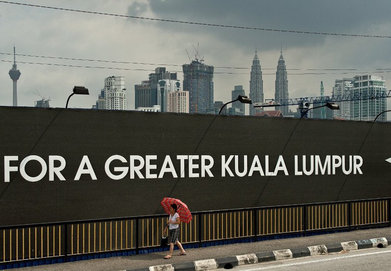 A woman walks past the construction site of the 1Malaysia Development Berhad (1MDB) flagship Tun Razak Exchange in Kuala Lumpur, July 3, 2015. A woman walks past the construction site of the 1Malaysia Development Berhad (1MDB) flagship Tun Razak Exchange in Kuala Lumpur, July 3, 2015.
