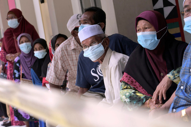 Voters wear masks to help curb the spread of COVID-19 as they wait for their turn to vote in state elections at a polling station near Kota Kinabalu, the capital of Malaysia’s Sabah state, Sept. 26, 2020. [AP] 