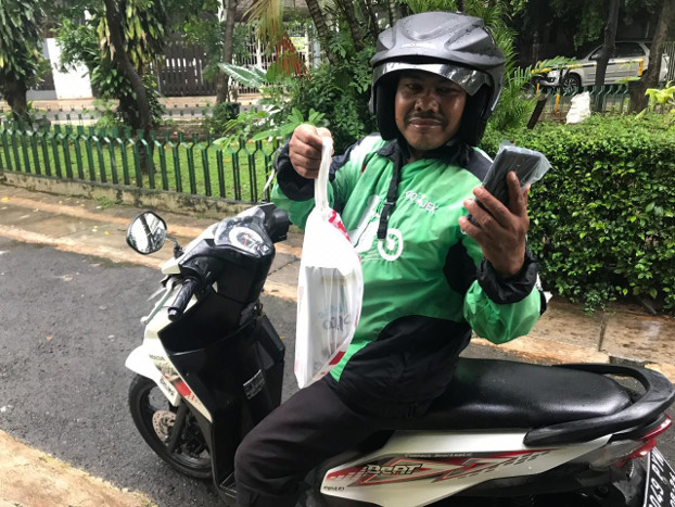Joni Yanto, an app-based motorcycle taxi driver, shows food he is about to deliver in Jakarta, March 20, 2020. [Ronna Nirmala/BenarNews]
