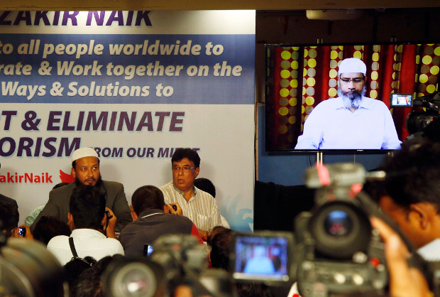 Indian journalists ask questions to Islamic preacher Zakir Naik (right) during a video conference in Mumbai, India, July 15, 2016. [AP]