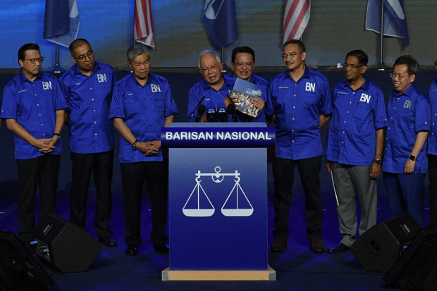 Barisan Nasional chairman Najib Razak holds a copy of his party’s campaign manifesto in Kuala Lumpur, April 7, 2018. [S.Mahfuz/BenarNews]