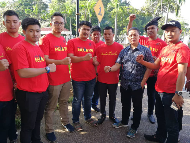 UMNO youth leader Noor Hariri Mohd Noor (in blue) poses with a group of men from Kelantan state who arrived at the court complex at 5:30 a.m. to show support for the former prime minister. [N. Nantha/BenarNews]