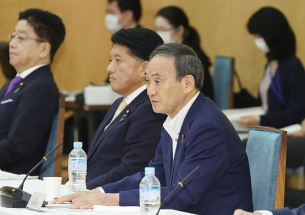 Japanese Prime Minister Yoshihide Suga (right) speaks to officials during a meeting on digital reform in Tokyo, Sept. 25, 2020. (AFP)