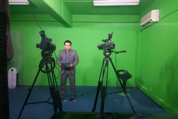 Presenter and journalist Ajmeer Omar records a stand-up report at the Rohingya Vision TV studio in Ampang, Kuala Lumpur. [Courtesy of Rohingya Vision TV]