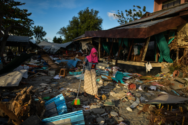 A woman clears debris from her house in Palu, in Indonesia's Central Sulawesi province, in the aftermath of a devastating earthquake and tsunami last month, on Oct. 8, 2018. [AFP]