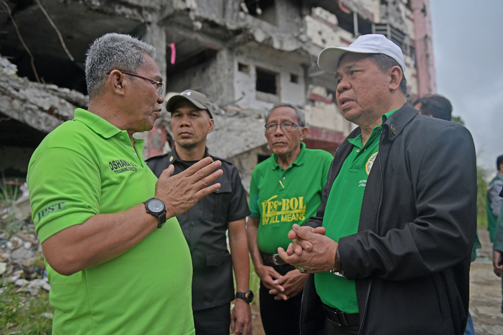 Murad Ebrahim (right), chairman of the Moro Islamic Liberation Front, talks to supporters while campaigning for the Bangsamoro Organic Law on regional autonomy, in the battle-ravaged southern Philippine city of Marawi, Dec. 22, 2018. [Froilan Gallardo/BenarNews] 