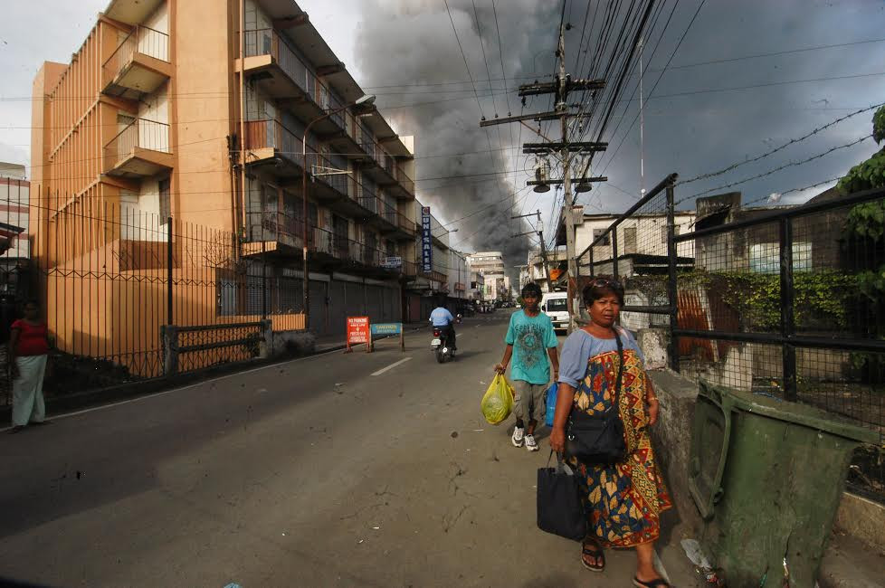 Smoke from fighting between government forces and MNLF rebels billows above downtown Zamboanga City, southern Philippines, in September 2013. [Froilan Gallardo/BenarNews] 