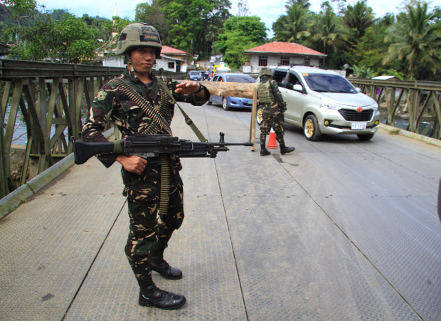 A sentry guards a bridge in Marawi city, March 20, 2018. 