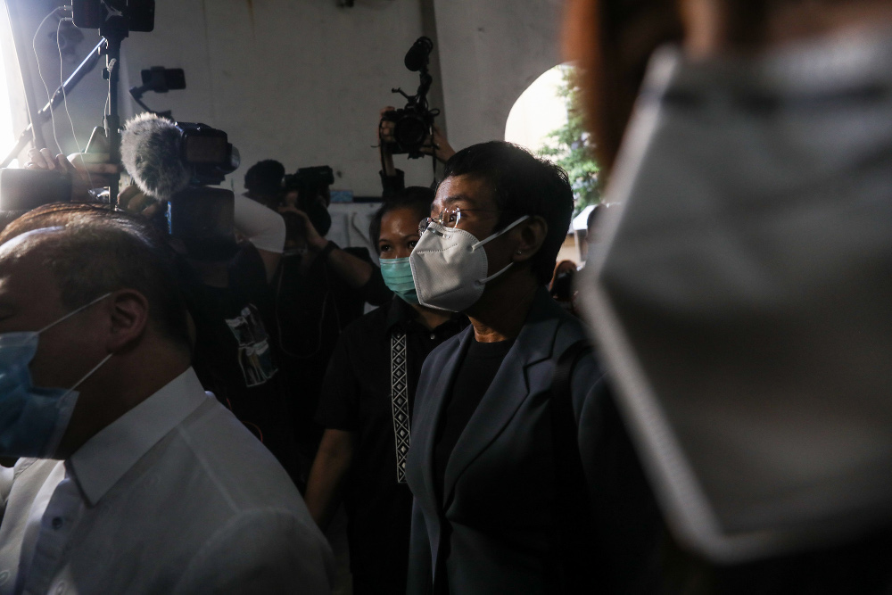 Philippine journalist Maria Ressa (wearing a dark jacket, eyeglasses and face mask) leaves a courtroom in Manila after being convicted in a cyber-libel case, June 15, 2020. [Basilio Sepe/BenarNews] 