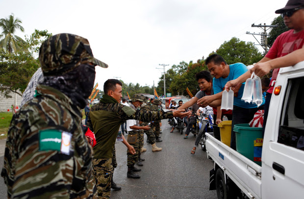 Moro Islamic Liberation Front (MILF) guerrillas provide security as thousands of people arrive in the southern Philippine province of Maguindanao to join a rally to push for the passage of a law that would give autonomy in the troubled south, Nov. 27, 2017. 