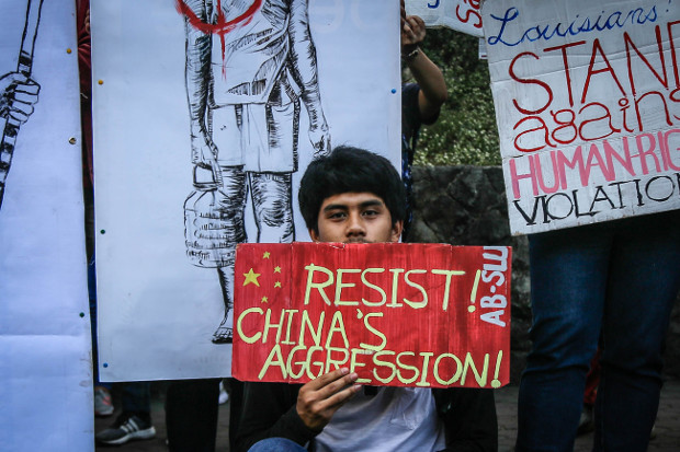 A student holds up a placard during a protest by hundreds of demonstrators in Baguio city, northern Philippines, against Chinese territorial expansion in the South China Sea, Feb. 23, 2018. [Karl Romano/BenarNews] 