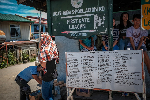 Names of missing persons and people whose bodies were recovered after the landslide are listed on a white board in Itogon, Philippines, Sept. 18, 2018. 