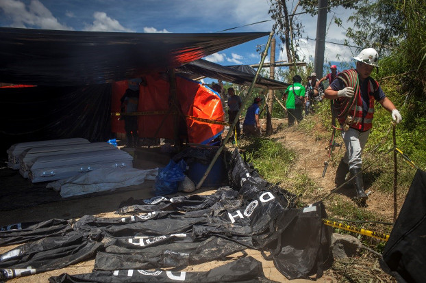 A rescuer walks past body bags and caskets at a command center in Itogon, Philippines, Sept. 19, 2018. [Luis Lawanag/BenarNews]