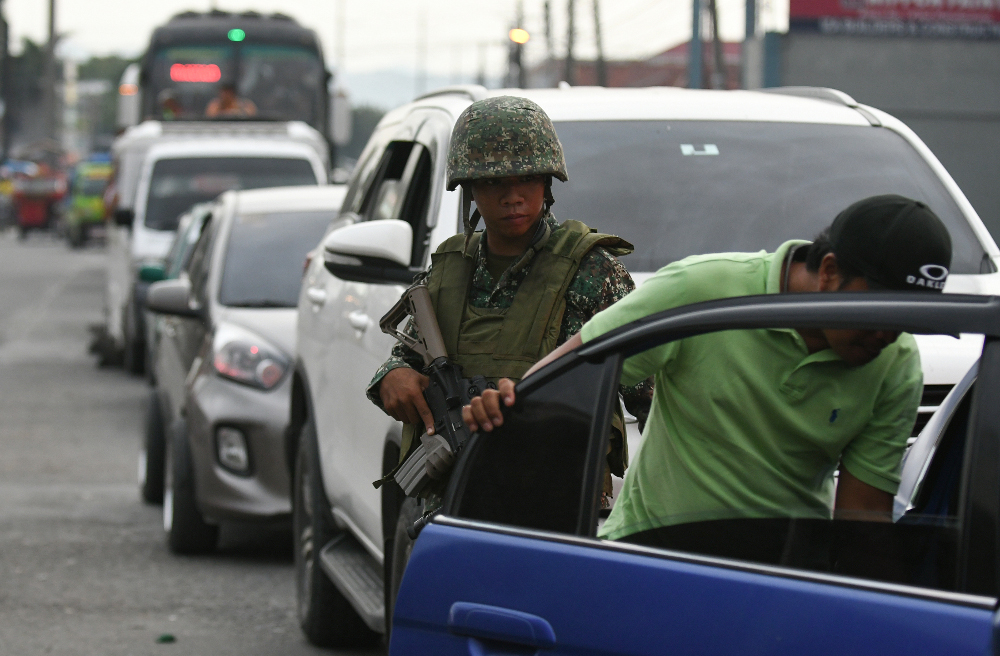 A government soldier inspects a vehicle at a checkpoint in Cotabato city, southern Philippines, ahead of an official ceremony to demobilize hundreds of former MILF guerrillas, Sept. 7, 2019, Sept. 7, 2019. (Photo: Froilan Gallardo/BenarNews)