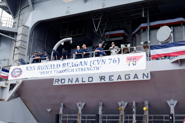 Crew members of the USS Ronald Reagan unfurl a banner on the ship’s deck, Aug. 7, 2019. [Jason Gutierrez/BenarNews]