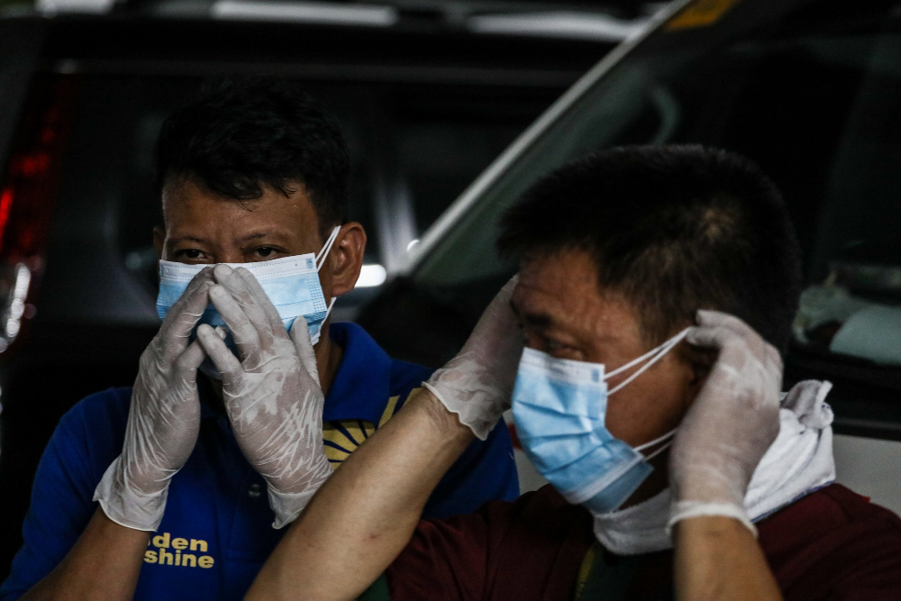 Workers adjust face masks as they prepare to help disinfect a mosque in Suan Juan district in Metro Manila, after Philippine health officials confirmed that a man who had frequented the worship space had tested positive for COVID-19, March 6, 2020. [Basilio Sepe/BenarNews]