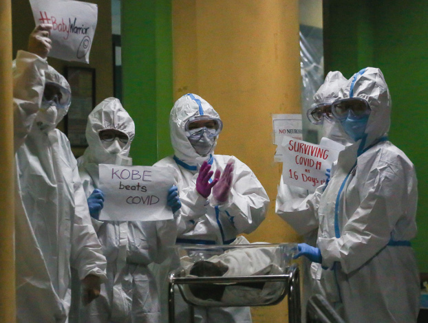 Children’s National Hospital staff wearing full personal protective equipment applaud the release of a 16-day-old COVID-19 survivor, April 28, 2020. [Basilio Sepe/BenarNews]