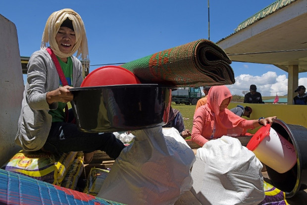 An evacuee sorts out a wash basin and a sleeping mat among relief items distributed by the International Committee of the Red Cross in Marogong, a town in Lanao del Sur province, southern Philippines, March 31, 2019. [Froilan Gallardo/BenarNews]