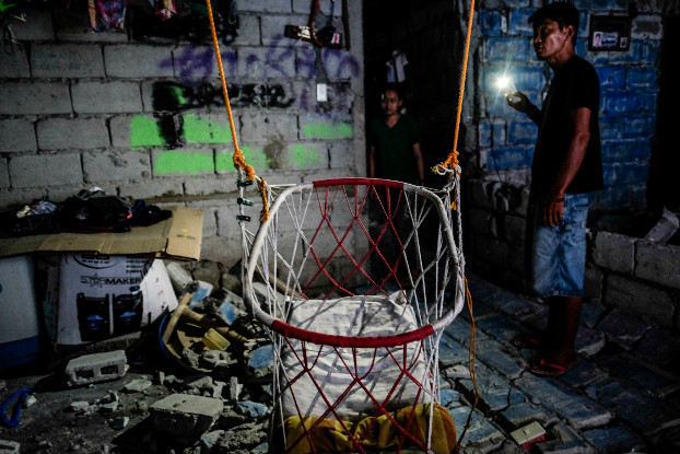 Janine Buan and her neighbor survey damage inside her house in Porac, Pampanga province, following Mnday’s earthquake, April 23, 2019. (Jojo Rinoza/BenarNews)