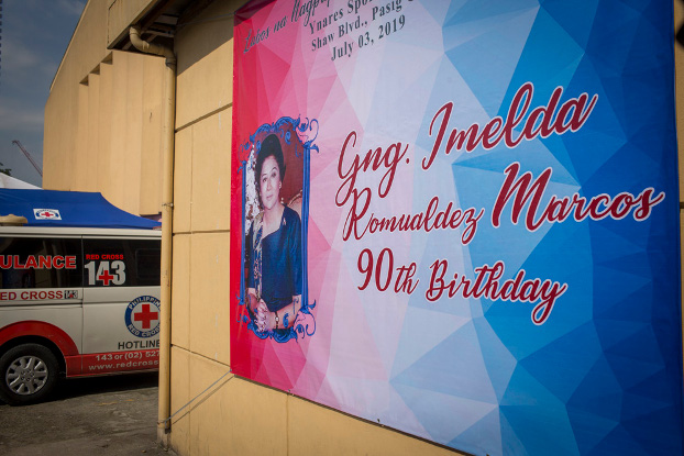 A poster announcing the 90th birthday of former Philippine first lady Imelda Marcos hangs outside the sports complex where party-goers were treated after becoming ill, July 3, 2019. (Luis Liwanag/BenarNews)