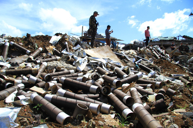 Philippine troops stand near artillery shells in a recently cleared neighborhood of Marawi city, in October 2017. 