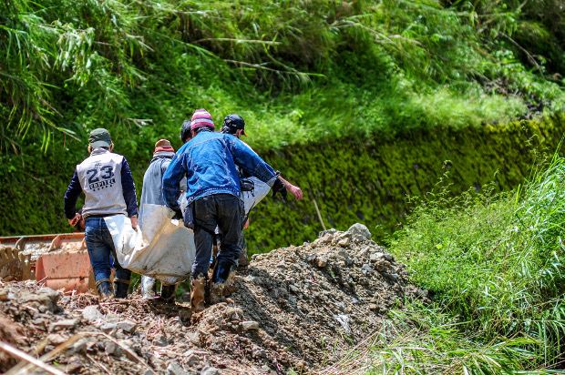 The body of Edwin Banawol, the president of the mining cooperative at Bgy. Ucab who was killed in the landslide, is carried to a command center in Ucab, Itogon after it was recovered by a search team, Sept. 18, 2018. 