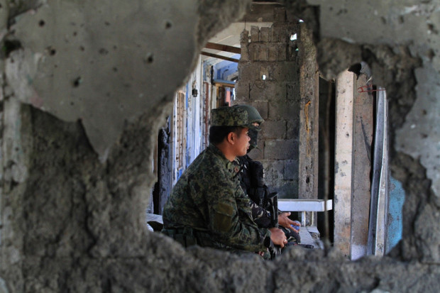 Soldiers watch as residents return to their ruined homes in southern Philippine city of Marawi, April 4, 2018. [Richel V. Umel/BenarNews]