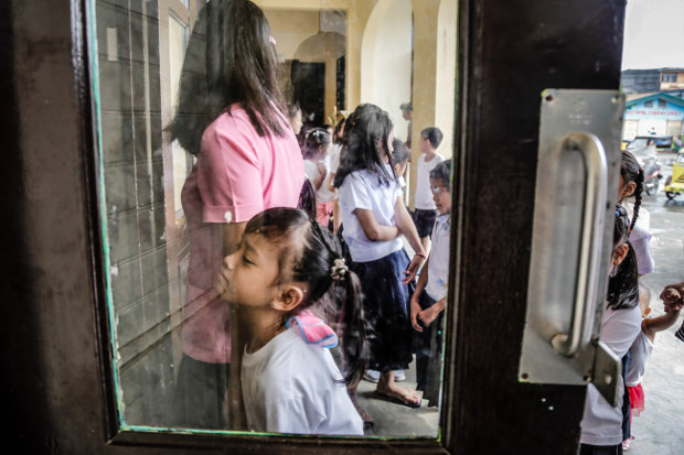 Pupils line up at an immunization center at an elementary school to have free booster shots against diseases like measles, rubella, diphtheria, tetanus and HPV vaccine administered in Dagupan City, Philippines, Aug. 2, 2017. (Karl Romano/BenarNews) 