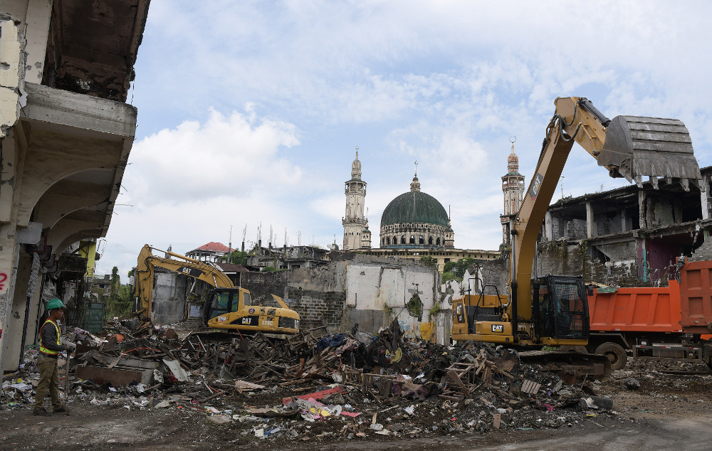 Excavators tear down buildings and clear debris in the southern Philippine city of Marawi in front of what remains of the city’s Grand Mosque, Sept. 4, 2019. (Photo: Froilan Gallardo/BenarNews)