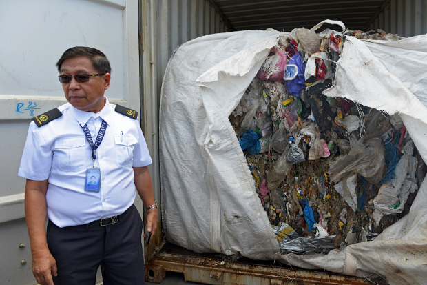 A Philippine customs official stands next to a shipping container filled with garbage that was returned to Seoul after it was shipped to a port in the southern Philippines from South Korea, Jan. 13, 2019. [Froilan Gallardo/BenarNews]