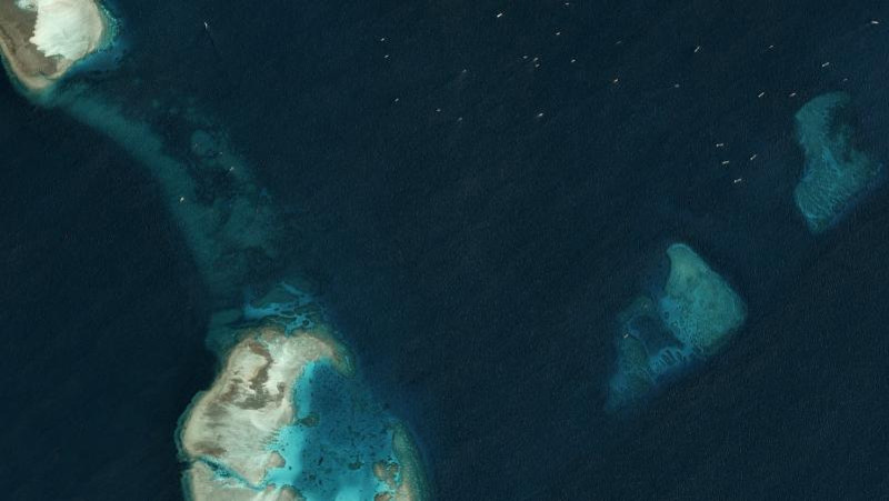 Multiple, unidentified vessels can be seen in the top right-hand corner of this satellite image taken just north of the Chinese-occupied base at South Johnson Reef March 22, 2020. [Planet Labs Inc.] 