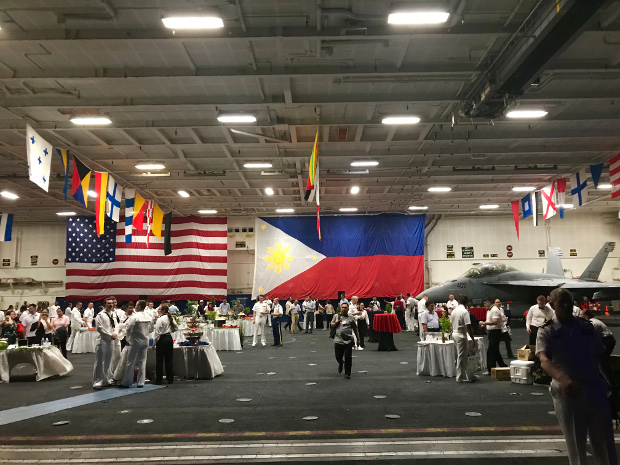 A huge Philippine flag is displayed beside an American flag at the USS Theodore Roosevelt when the aircraft carrier visited the Philippines in April after a "freedom of navigation" voyage that passed through the South China Sea, April 2018. [Felipe Villamor/BenarNews]