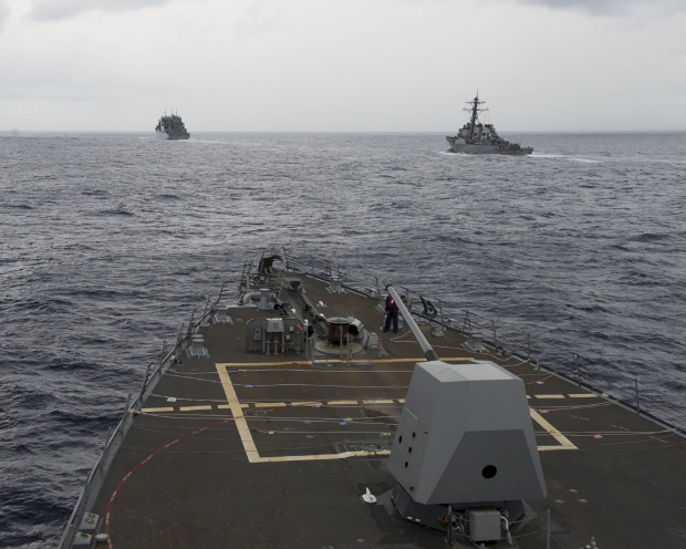 The guided missile destroyer USS Decatur (right) pulls into position behind the Military Sealift Command USNS Matthew Perry, seen from the bridge of USS Spruance, during a freedom-of-navigation operation in the South China Sea, Oct. 21, 2016. [AP]