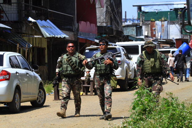 Philippine troops guard hundreds of residents who were allowed to visit their ruined homes in the southern city of Marawi, April 4, 2018. [Richel V. Umel/BenarNews]