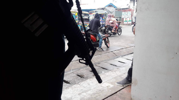 A soldier armed with an assault rifle guards a busy street in the southern Philippine town of Jolo, April 10, 2019. [Mark Navales/BenarNews]
