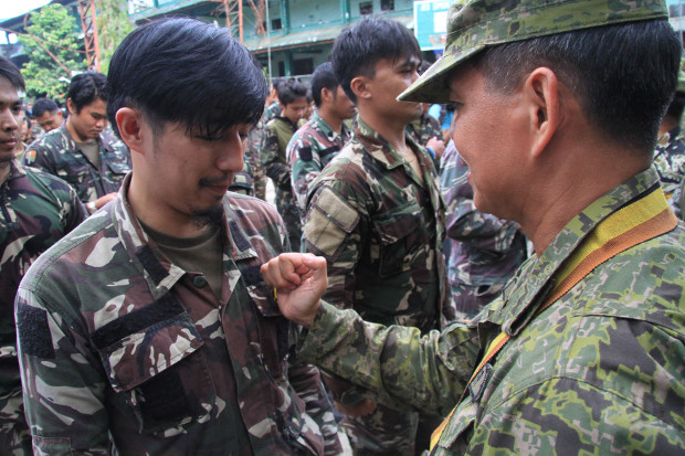 Lt. Gen. Rolando Joselito Bautista, Philippine Army chief, pins a Special Forces badge to the graduates of Special Forces and Scout Rangers after five months of fighting against Islamic State militants in Marawi city, Oct. 23, 2017. 