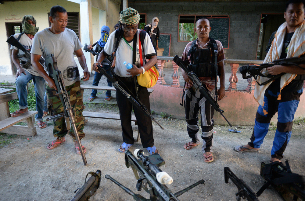 Members of the Bangsamoro Islamic Freedom Fighters (BIFF), a Muslim group that has pledged allegiance to the Islamic State, show off their weapons during an interview in the southern Philippine province of Maguindanao, March 28, 2014. (Photo: AFP)