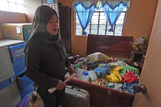 Baicona Hassan is emotional as she looks at a ransacked room in her house in Basak Malotlot, a village in the southern Philippine city of Marawi, Oct. 26, 2017. [Froilan Gallardo/BenarNews]