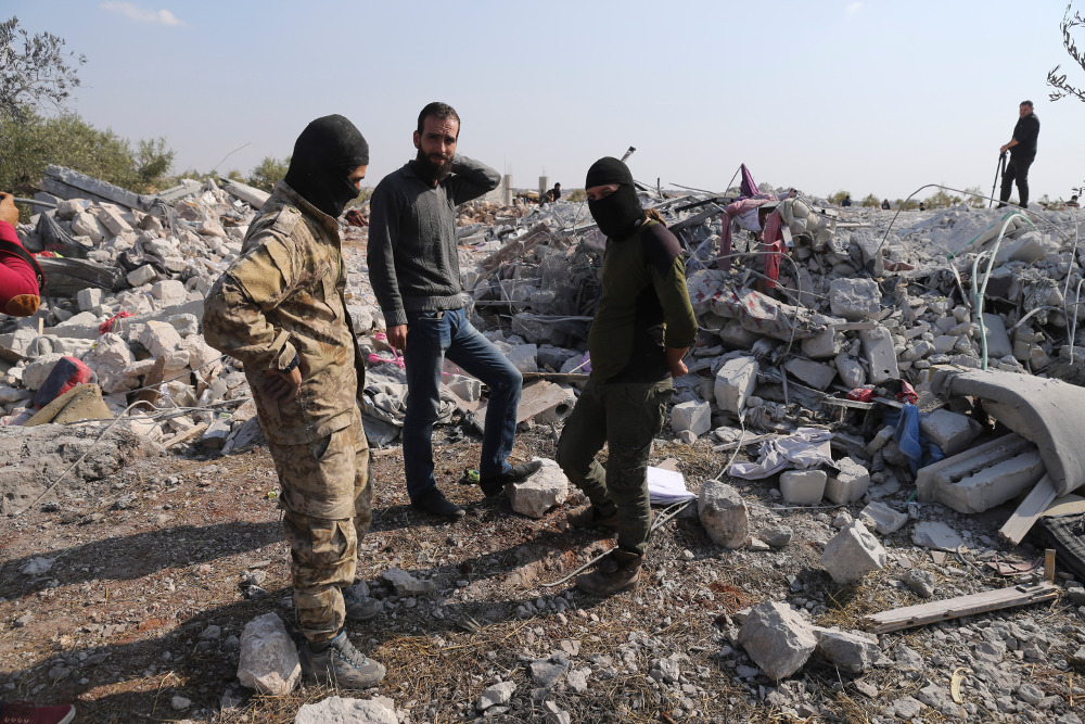 People look at a destroyed house near the village of Barisha in Syria’s Idlib province, after a U.S. military operation that killed Islamic State leader Abu Bakr al-Baghdadi, Oct. 27, 2019. (Photo: AP)