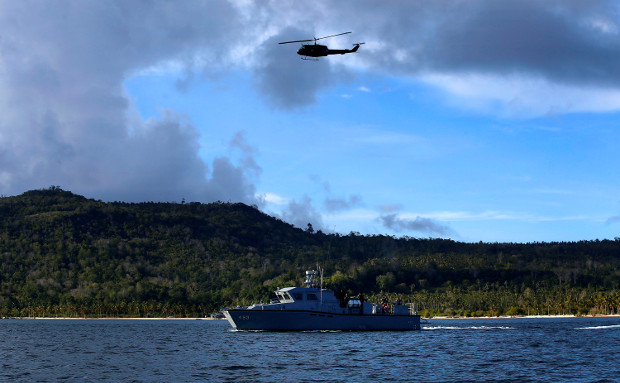 A Huey helicopter flies above a Philippine Coast Guard vessel circling the coastline in the southern Philippine province of Sulu, as state security forces tightened the security to thwart possible attacks by Islamic State militants, Oct. 22, 2019. (Photo: Mark Navales/BenarNews)