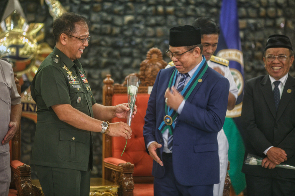 Moro Islamic Liberation Front (MILF) leader Murad Ebrahim smiles as the Philippine military’s chief of staff, Gen. Carlito Galvez, offers him a flower during his visit at Camp Aguinaldo in Quezon city, Metro Manila, Nov. 19, 2018. [Luis Liwanag/BenarNews]