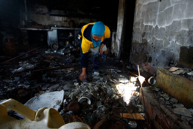 A woman looks for family mementoes to salvage from her home in the southern Philippine city of Marawi, which was flattened by five months of aerial bombings and firefights between government forces and pro-Islamic State militants, Nov. 23, 2017. [Mark Navales/BenarNews]