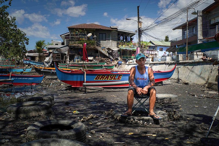 Leonardo Cuaresma, one of the local leaders of the fishermen’s group Pamalakaya, sits near the waterside in Masinloc, Feb. 26, 2024. (Jojo Riñoza/BenarNews)