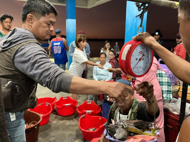 ENG_PAC_SCSseries2.6 A fisherman weighs his catch at the market in Masinloc, Feb. 27, 2024. (Jojo Riñoza/BenarNews)