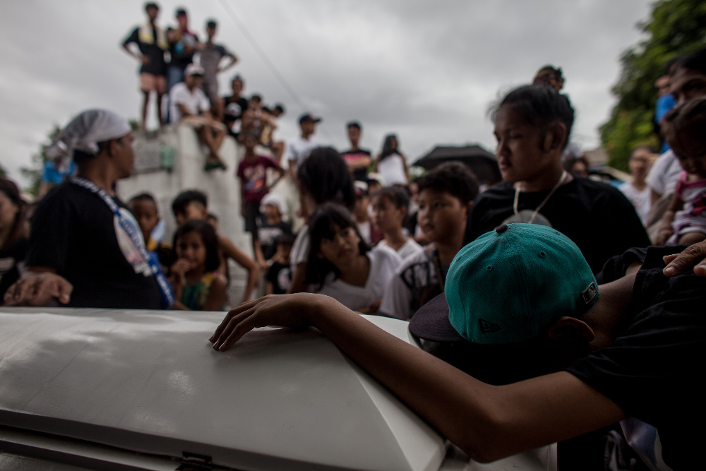 Relatives and friends of Jaybee Castor, who was found dead with a sign that read “I am an addict,” attend his burial at the Manila North Cemetery in Manila, July 18, 2019. [Basilio Sepe/BenarNews]