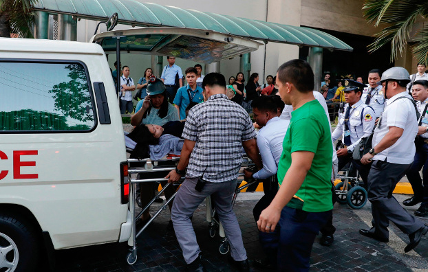 Rescue workers in Manila carry a woman to an ambulance after she became dizzy following an earthquake that hit near the capital, April 22, 2019. (AP)
