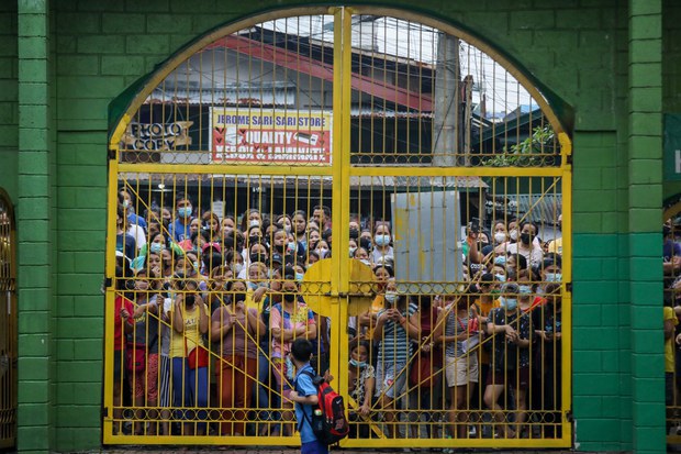 Parents watch a boy walk to his school on the first day of classes in Quezon City, Philippines, Aug. 22, 2022. Basilio Sepe/BenarNews