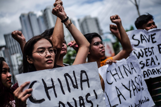 Protesters raise their fists and carry anti-China signs during a protest rally in front of the Chinese Embassy in Manila, April 9, 2019. (Jojo Rinoza/BenarNews)