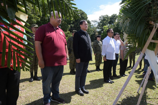 Philippine officials led by Task Force Bangon Marawi chairman Eduardo del Rosario (in black) and Presidential Peace Adviser Carlito Galvez (in white) lay a wreath at a marker in honor of  more than 160 soldiers and police killed during the five months of fighting in Marawi City, Oct. 17, 2019. [Froilan Gallardo/BenarNews]